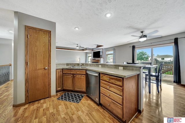 1035 Primrose Ln, Hickman, NE 68372 - kitchen with stainless steel dishwasher, ceiling fan, brown cabinetry, a sink, and light wood-style floors