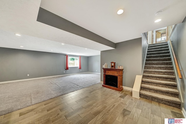 1035 Primrose Ln, Hickman, NE 68372 - below grade area with wood finished floors, baseboards, stairs, a fireplace, and recessed lighting