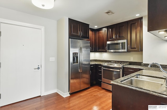3200 Farnam Ct Unit 3409, Omaha, NE 68131 - kitchen featuring appliances with stainless steel finishes, light wood finished floors, a sink, dark brown cabinetry, and recessed lighting