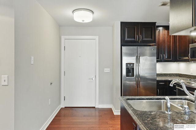 3200 Farnam Ct Unit 3409, Omaha, NE 68131 - kitchen featuring stainless steel appliances, a sink, dark wood finished floors, dark stone counters, and baseboards