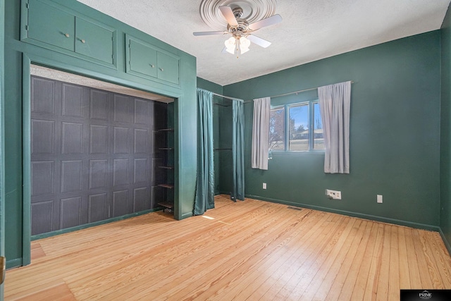 13602 S 36th St, Bellevue, NE 68123 - unfurnished bedroom with light wood-style floors, baseboards, a textured ceiling, and a ceiling fan