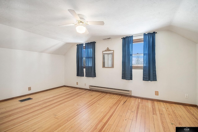 13602 S 36th St, Bellevue, NE 68123 - additional living space featuring a baseboard radiator, vaulted ceiling, a textured ceiling, ceiling fan, and baseboards