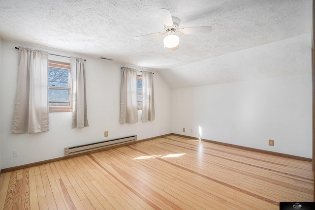 13602 S 36th St, Bellevue, NE 68123 - additional living space featuring baseboard heating, a textured ceiling, wood-type flooring, healthy amount of natural light, and baseboards