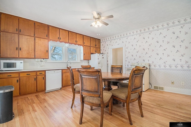 13602 S 36th St, Bellevue, NE 68123 - dining space with wallpapered walls, light wood finished floors, ceiling fan, and baseboards