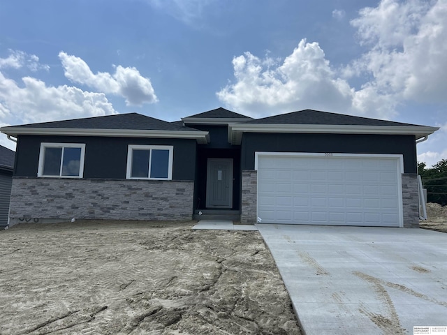 7703 S 34th St, Bellevue, NE 68147 - prairie-style house with stone siding, concrete driveway, and an attached garage