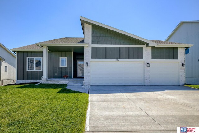 9221 S 177th St, Omaha, NE 68136 - view of front of property featuring a garage, concrete driveway, a front yard, roof with shingles, and board and batten siding