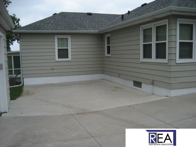 4521 A St, Omaha, NE 68106 - view of side of home with a shingled roof and a patio