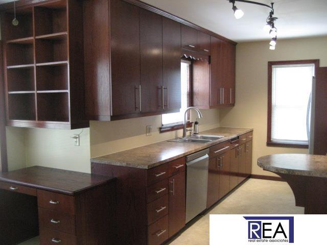 4521 A St, Omaha, NE 68106 - kitchen featuring stainless steel appliances, dark countertops, and dark brown cabinets
