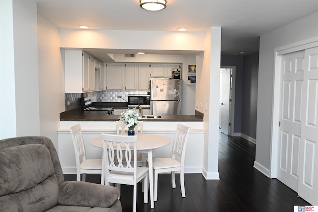 139 N 11th St Unit 904, Lincoln, NE 68508 - kitchen with stainless steel appliances, backsplash, dark countertops, dark wood-style floors, and open floor plan
