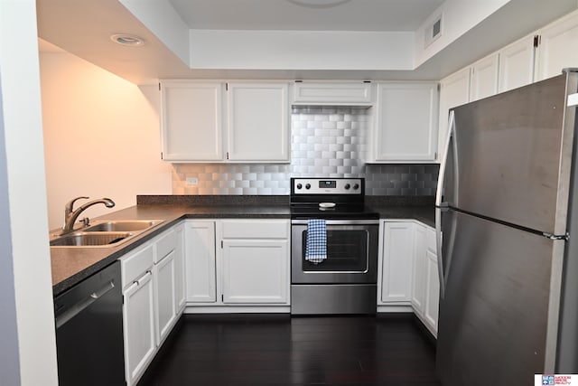 139 N 11th St Unit 904, Lincoln, NE 68508 - kitchen with stainless steel appliances, dark countertops, white cabinetry, dark wood finished floors, and tasteful backsplash