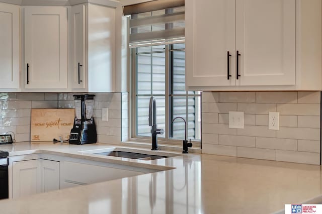 8178 Regent Dr, Lincoln, NE 68507 - kitchen with white cabinets, light countertops, and backsplash
