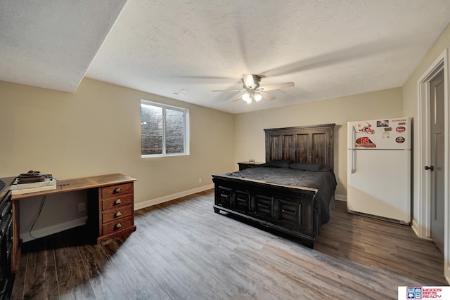 8178 Regent Dr, Lincoln, NE 68507 - bedroom with freestanding refrigerator, wood finished floors, a textured ceiling, and a ceiling fan