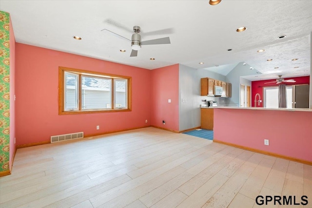 3018 Frederick St S, Omaha, NE 68105 - unfurnished living room featuring ceiling fan, healthy amount of natural light, light wood-style floors, and recessed lighting
