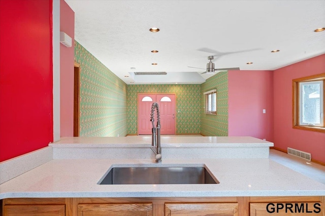 3018 Frederick St S, Omaha, NE 68105 - kitchen featuring wallpapered walls, healthy amount of natural light, light stone counters, ceiling fan, and recessed lighting