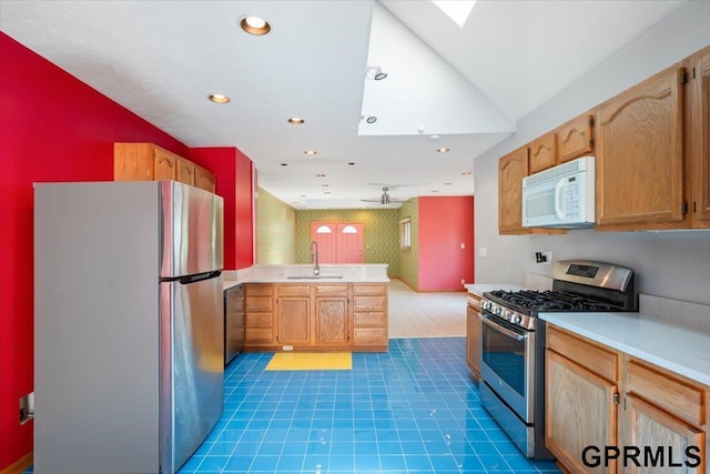 3018 Frederick St S, Omaha, NE 68105 - kitchen with stainless steel appliances, a peninsula, light countertops, a skylight, and recessed lighting
