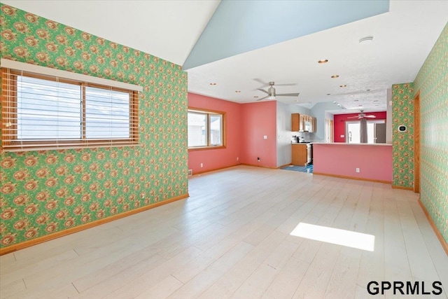 3018 Frederick St S, Omaha, NE 68105 - unfurnished living room with ceiling fan, wallpapered walls, light wood finished floors, and vaulted ceiling