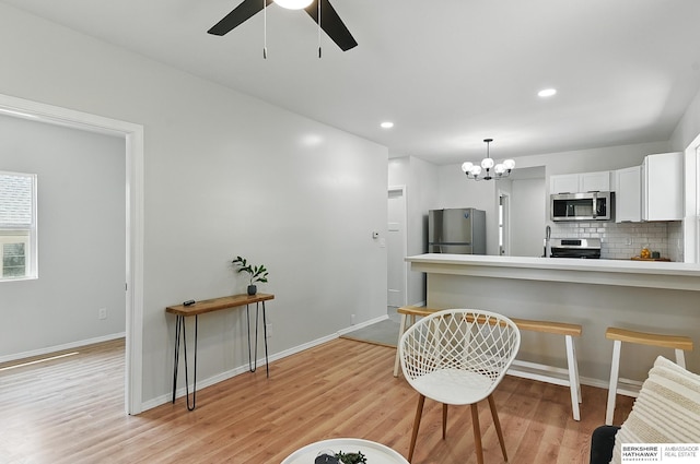 3410 U St, Omaha, NE 68107 - kitchen with stainless steel appliances, a ceiling fan, light wood finished floors, backsplash, and white cabinets