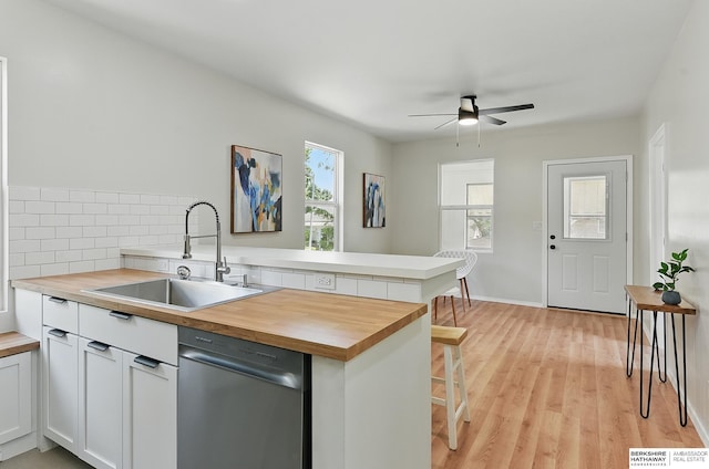 3410 U St, Omaha, NE 68107 - kitchen with butcher block counters, dishwasher, a peninsula, a ceiling fan, and light wood finished floors