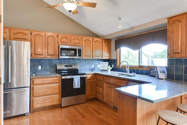 6705 Hillcrest Ln, La Vista, NE 68128 - kitchen with stainless steel appliances, vaulted ceiling, a peninsula, a kitchen bar, and ceiling fan