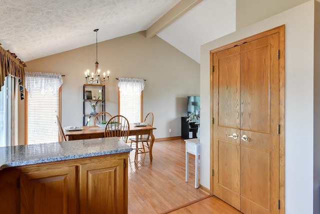 6705 Hillcrest Ln, La Vista, NE 68128 - kitchen with a chandelier, light wood-style flooring, light stone counters, pendant lighting, and brown cabinets