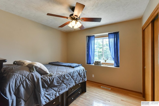6705 Hillcrest Ln, La Vista, NE 68128 - bedroom featuring light wood-type flooring, a textured ceiling, a ceiling fan, and a closet