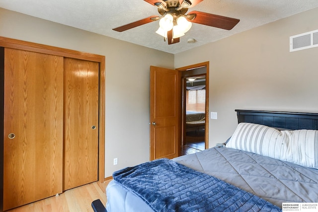 6705 Hillcrest Ln, La Vista, NE 68128 - bedroom with light wood-style floors, a closet, a ceiling fan, and a textured ceiling