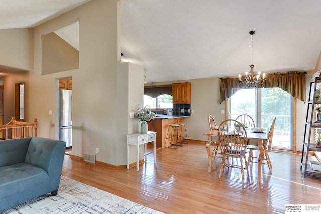 6705 Hillcrest Ln, La Vista, NE 68128 - dining area with plenty of natural light, light wood-style floors, a chandelier, and vaulted ceiling