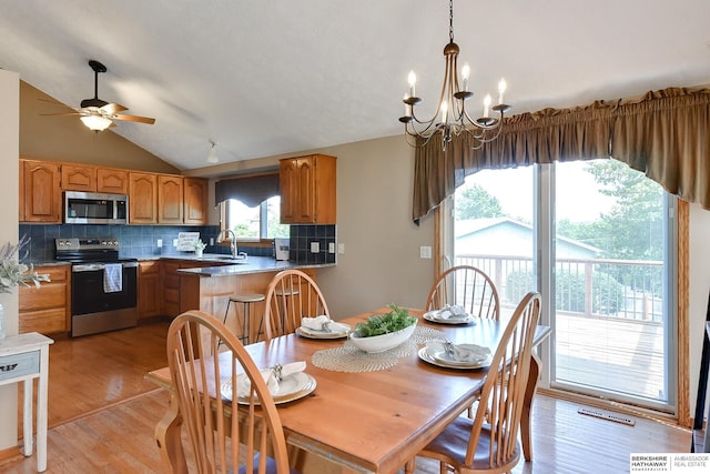 6705 Hillcrest Ln, La Vista, NE 68128 - dining area featuring ceiling fan, a chandelier, vaulted ceiling, and light wood finished floors