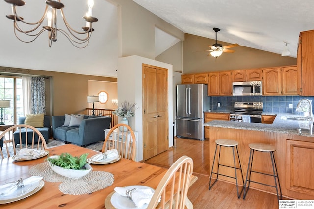 6705 Hillcrest Ln, La Vista, NE 68128 - dining area featuring light wood-style flooring, high vaulted ceiling, a ceiling fan, and a chandelier