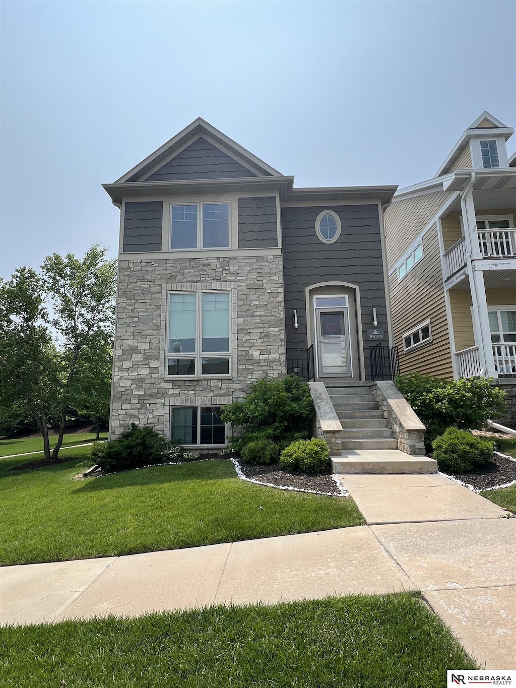 5933 Minter Ln, Lincoln, NE 68516 - view of front of house with stone siding and a front yard