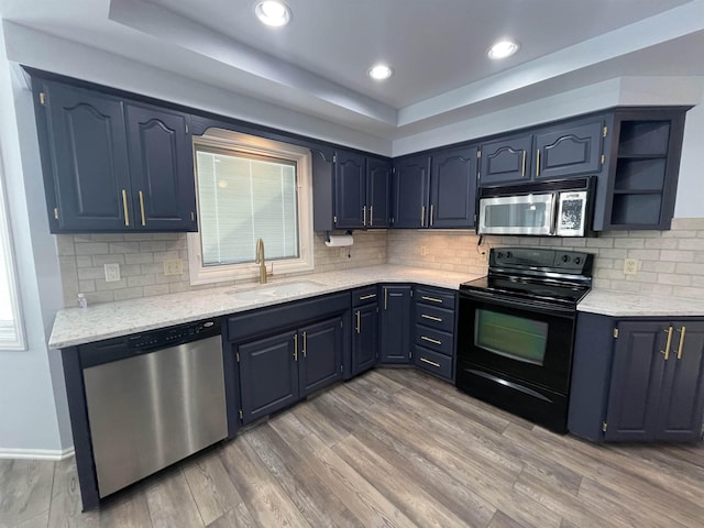 13406 Erskine St, Omaha, NE 68164 - kitchen featuring stainless steel appliances, light wood-type flooring, a tray ceiling, blue cabinets, and recessed lighting