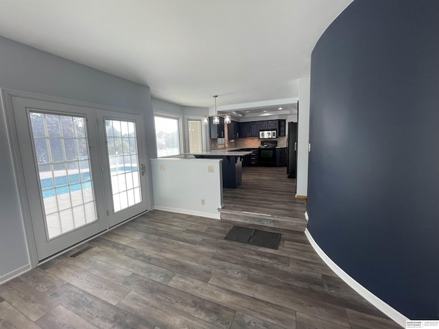 13406 Erskine St, Omaha, NE 68164 - kitchen with black appliances, a peninsula, dark wood finished floors, light countertops, and decorative light fixtures