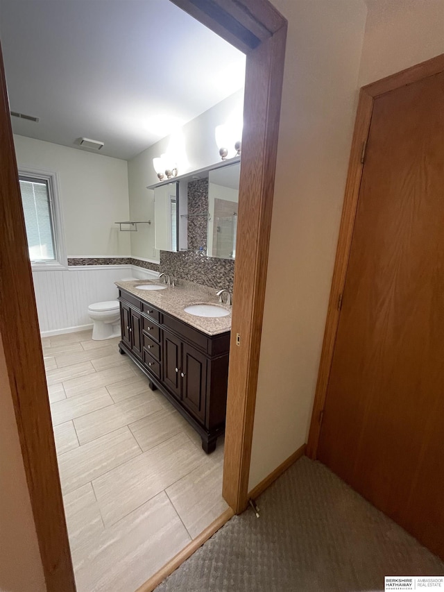 13406 Erskine St, Omaha, NE 68164 - bathroom featuring double vanity and a wainscoted wall