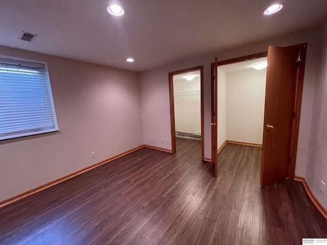 13406 Erskine St, Omaha, NE 68164 - unfurnished bedroom featuring dark wood-style floors, baseboard heating, recessed lighting, a walk in closet, and a closet