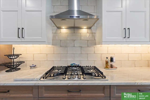 5850 Country Squire Plz, Omaha, NE 68152 - kitchen featuring wall chimney range hood, stainless steel gas stovetop, decorative backsplash, and white cabinetry
