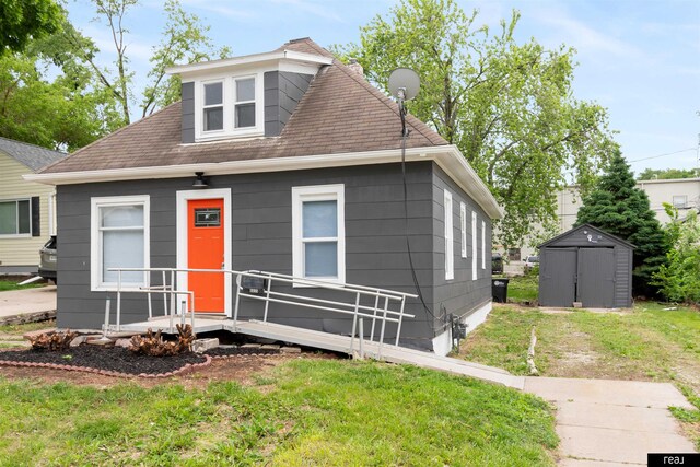 6935 Binney St, Omaha, NE 68104 - view of front of home with a storage unit, a front yard, and roof with shingles