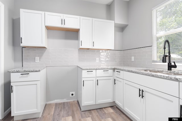 1204 S 27th St, Omaha, NE 68105 - kitchen featuring light stone counters, white cabinets, and healthy amount of natural light