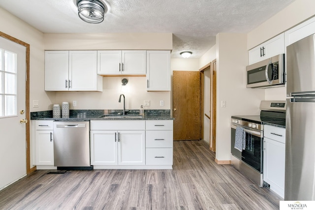5424 Canterbury Ln Unit 5424, Lincoln, NE 68512 - kitchen with stainless steel appliances, light wood-type flooring, white cabinets, and a textured ceiling