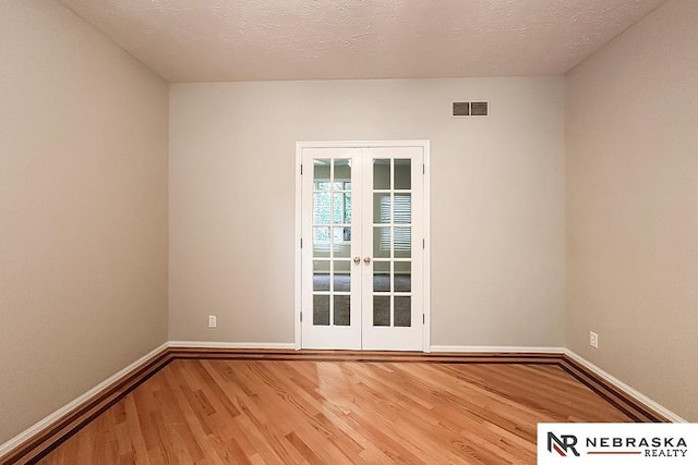 1425 S 158th Cir, Omaha, NE 68130 - spare room with french doors, wood finished floors, and a textured ceiling