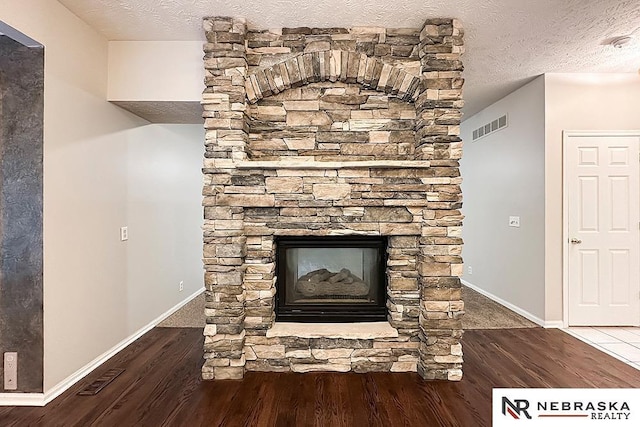 1425 S 158th Cir, Omaha, NE 68130 - detailed view of wood finished floors, a textured ceiling, and a stone fireplace