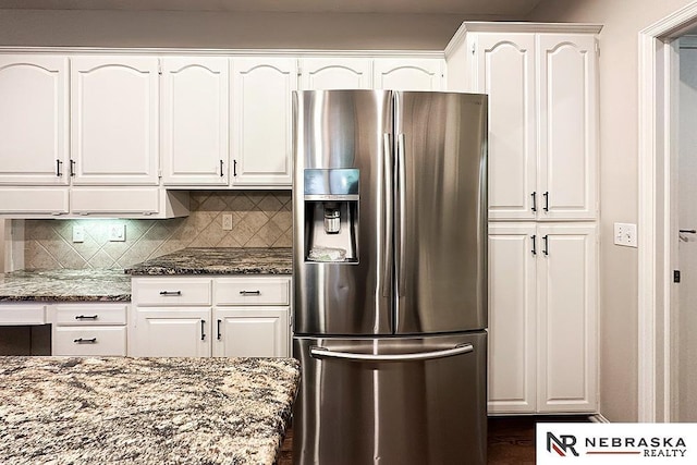 1425 S 158th Cir, Omaha, NE 68130 - kitchen featuring stainless steel fridge with ice dispenser, white cabinets, dark stone countertops, and tasteful backsplash