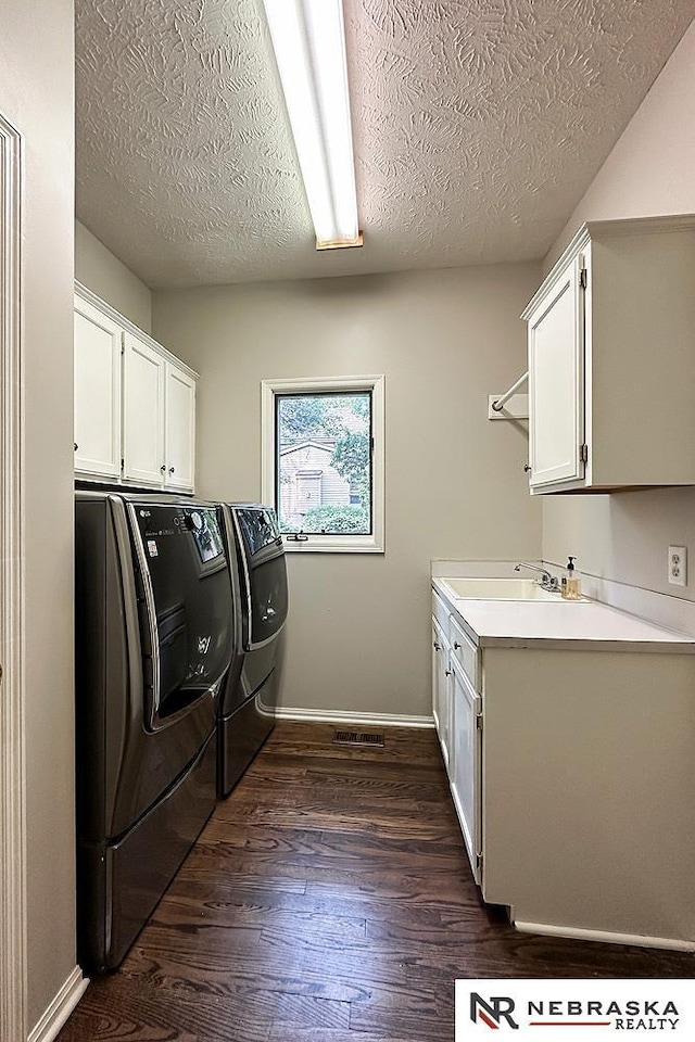 1425 S 158th Cir, Omaha, NE 68130 - laundry area featuring cabinet space, washer and dryer, a textured ceiling, and dark wood-style flooring