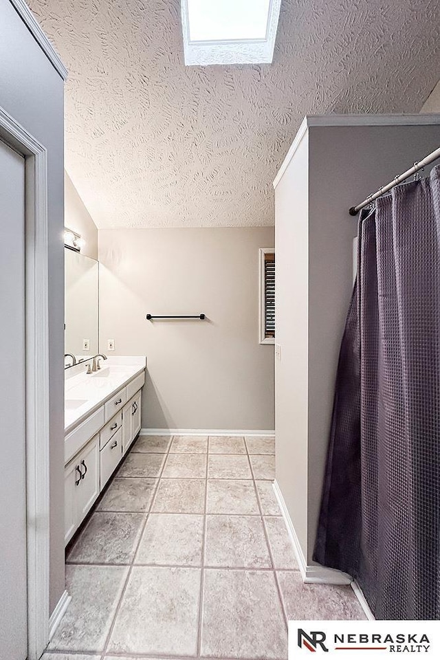 1425 S 158th Cir, Omaha, NE 68130 - full bath with double vanity, a textured ceiling, a skylight, and tile patterned floors