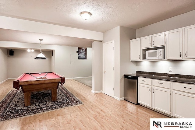 1425 S 158th Cir, Omaha, NE 68130 - kitchen with white microwave, stainless steel dishwasher, white cabinetry, light wood-style floors, and dark countertops