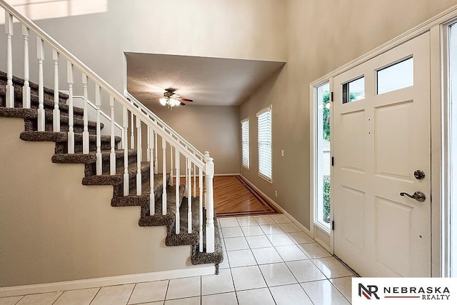 1425 S 158th Cir, Omaha, NE 68130 - foyer entrance featuring light tile patterned floors, stairs, ceiling fan, and a towering ceiling