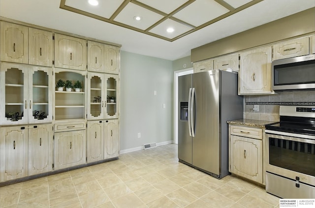 7504 S 46th Ave, Omaha, NE 68157 - kitchen with appliances with stainless steel finishes, recessed lighting, decorative backsplash, stone countertops, and light tile patterned floors
