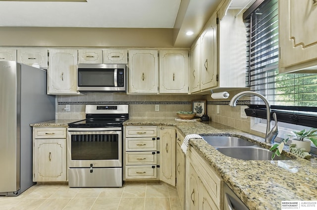 7504 S 46th Ave, Omaha, NE 68157 - kitchen with stainless steel appliances, backsplash, light tile patterned flooring, and light stone counters