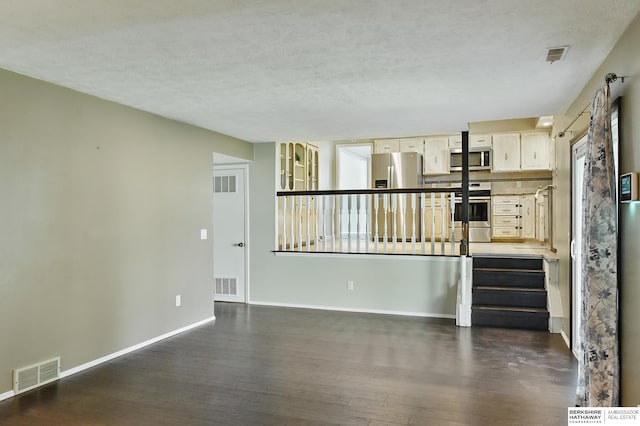 7504 S 46th Ave, Omaha, NE 68157 - unfurnished living room with dark wood-style floors and a textured ceiling