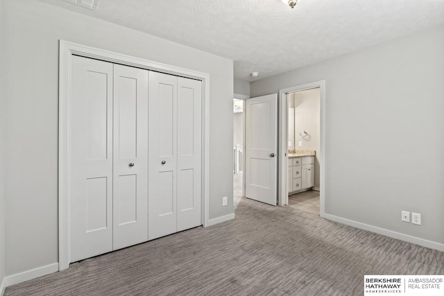 19014 Pratt Cir, Elkhorn, NE 68022 - unfurnished bedroom featuring a closet, carpet, a textured ceiling, and ensuite bathroom