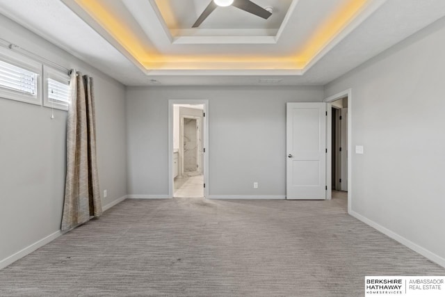 19014 Pratt Cir, Elkhorn, NE 68022 - unfurnished bedroom featuring a raised ceiling, ensuite bath, light colored carpet, and ceiling fan